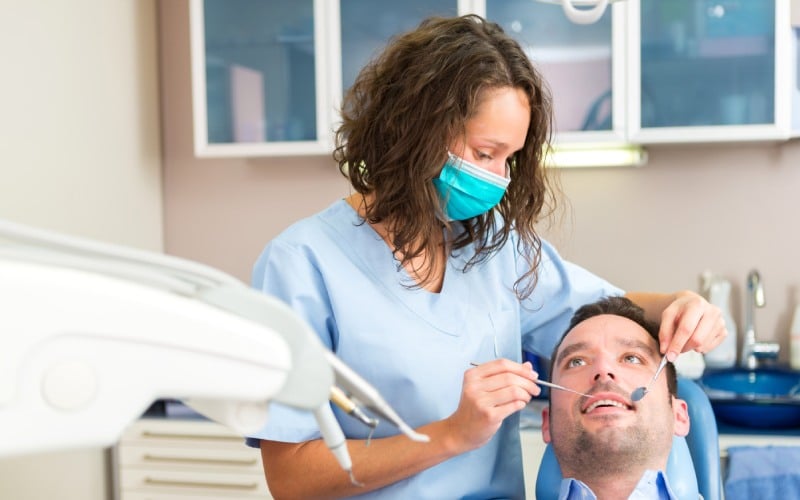 young attractive man being cured by a dentist