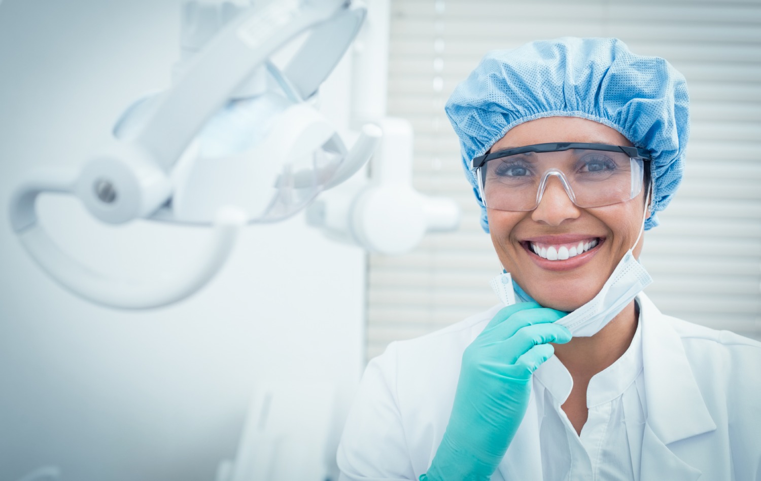 female dentist wearing surgical cap and safety glasses