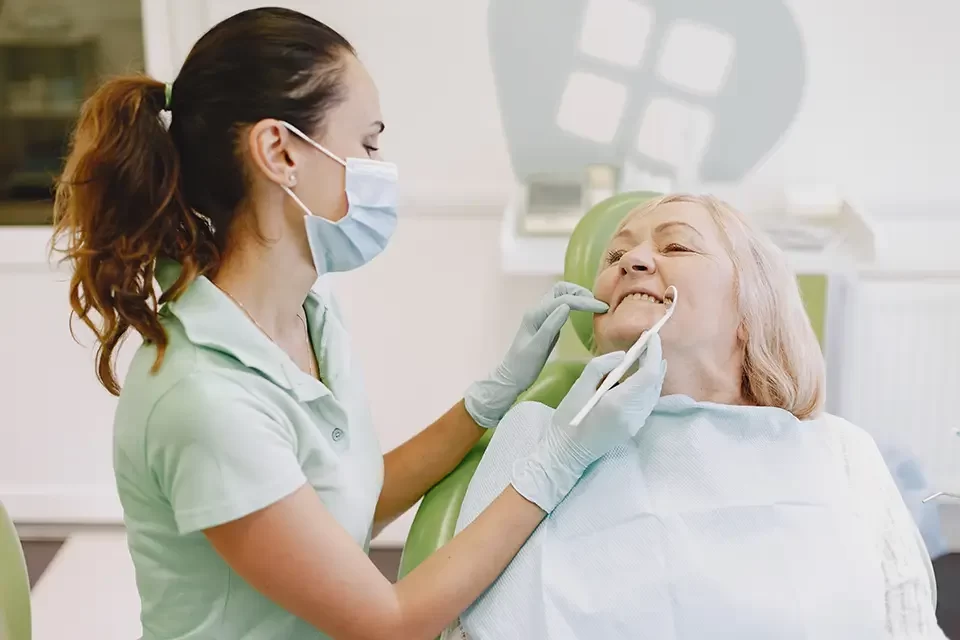 dentist-looking-her-old-patient-with-tools